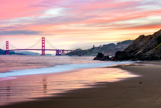 Beautiful Red dawn over the Golden Gate Bridge from a beach