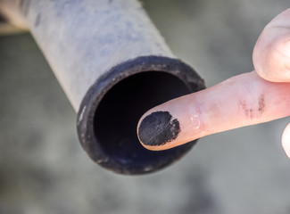 Soot from the exhaust pipe on the finger. Examination of the car's exhaust system by the automaker