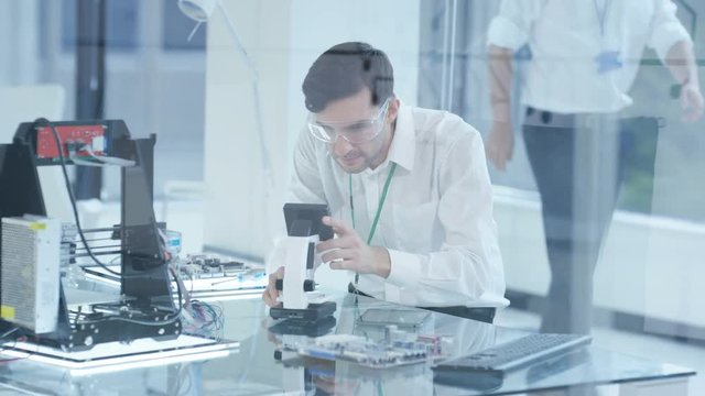  Electronic engineer working in the lab, testing 3D printer & circuit boards