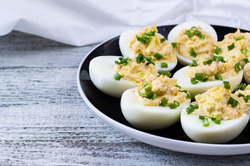 Home eggs stuffed with cheese and crab topped with green onions