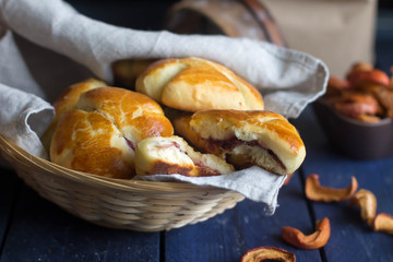 Freshly baked pastry bun with a dried fruits on rustic table. Easter cake food concept. Buns in a basket