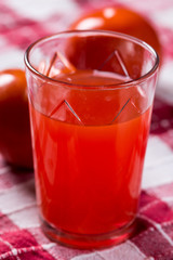Tomato juice in the glass with tomatos