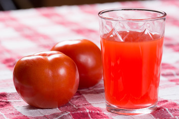 Tomato juice in the glass with fresh tomatos