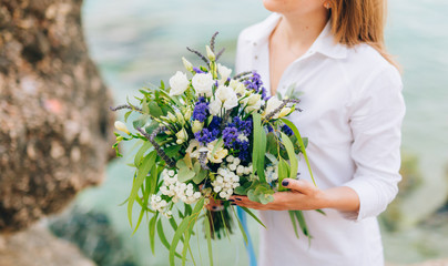Obraz na płótnie Canvas Wedding bridal bouquet of roses, lisianthus, lavender, Gypsophila, Verdure Italian in the hands of the bride. Wedding in Croatia, Dubrovnik.