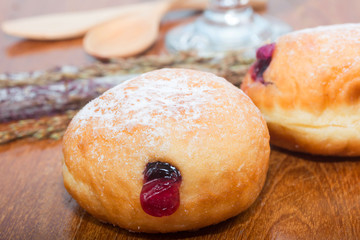 fresh donuts with jam isolated on wooden table
