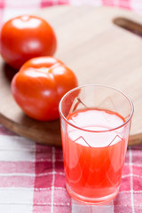Tomato juice in the glass with fresh tomatos