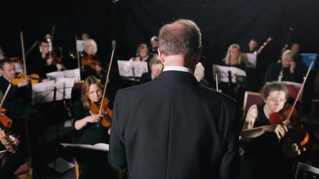  Symphony orchestra during a performance with close up on violinist. 