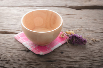 wooden bowl on pink napery and wood table.