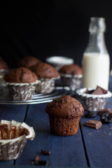 Homemade chocolate muffin with bottle of milk on a wooden table background. Mini cakes with chocolate