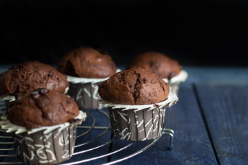 Homemade chocolate muffins on a dark wooden table tablebackground. Copy space. Mini cakes with chocolate