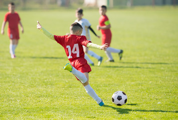 Obraz premium Kids soccer football - children players match on soccer field