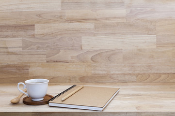 Coffee cup with notebook on wood table.