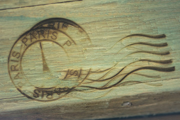 Paris rubber stamp burned on wooden background. Vintage wood background