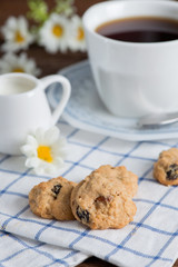 Homemade oatmeal and raisin cookies with a cup of coffee.