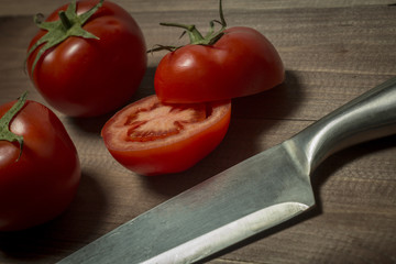The kitchen knife and cut the tomatoes on the board