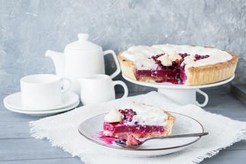 A piece of berry pie with a meringue served on a white dish