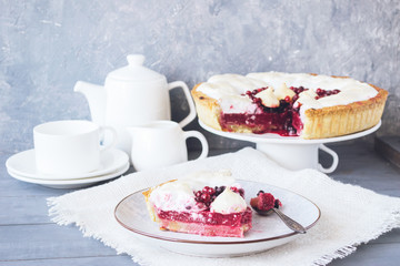 A piece of berry pie with a meringue served on a white dish