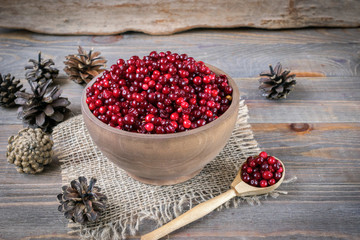 Ripe wild berry cranberries served in wooden plates, spoon and bowl