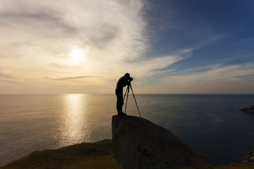 Silhouette of a photographer or traveler using a professional DSLR camera,photographer take sunset photo