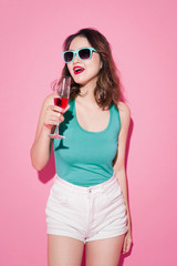 Celebrating asian girl with professional makeup and stylish hairstyle holding a glass of champagne.