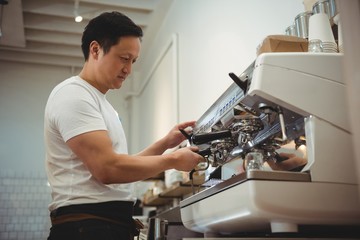 Barista using espresso machine in cafe