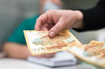The doctor takes money from the patient