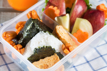 Lunch box, Rice wrapped in seaweed with sausage, egg and apple.