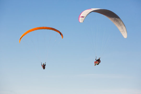 dos volando suspendidos en el cielo con su parapente