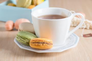 Colourful of french macarons with tea cup. Selective focus, focus too soft.