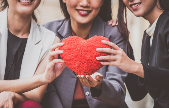 Businesswoman team giving a red heart to a customer on isolated background - customer relationship management