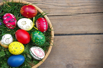 Easter eggs in the basket on rustic wooden background.