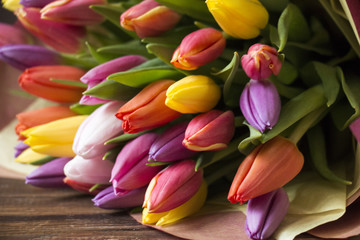 Bouquet of colorful  tulips on wooden background. Bunch of assorted flowers. Close up