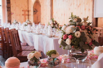 Stylishly decorated wedding table with flowers, candles, rose petals  in pink colors. Flower arrangement