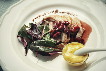 Tasty dish with chicken, beans and sauce on plate