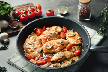 Frying pan with delicious chicken marsala on table