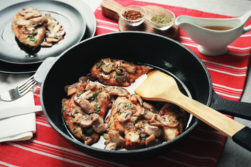Frying pan with delicious chicken marsala on table