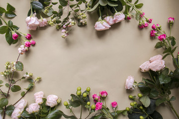 Border of  various roses on craft paper  background . Holiday mock up. Top view.