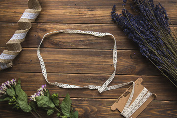Aromatic bunch of dried lavender and lace ribbon on  the rustic wooden background with place for text. View from above.