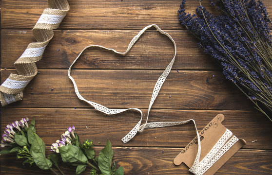 Aromatic bunch of dried lavender and lace ribbon on  the rustic wooden background. View from above.