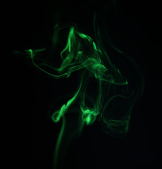 Fototapeta premium Swirl of green smoke on black background
