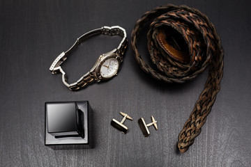 Fototapeta na wymiar Leather belt with perfume, watch and cuff