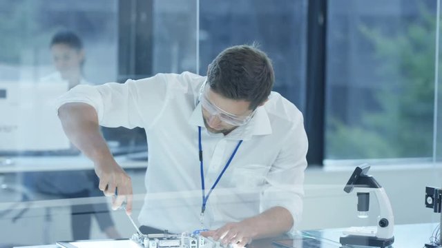  Electronic engineer working in the lab, testing 3D printer & circuit boards
