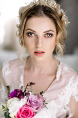 Beautiful girl in tender lacy dress with bouquet flowers peonies in hands standing against floral background in flower shop. Joyful asian female florist. Shy fashion model looking down and smiling.