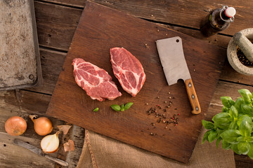 Raw pork steaks on cutting board