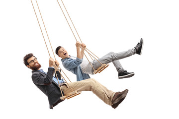 Joyful father and son swinging on wooden swings