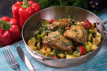  Fried chicken in a frying pan on a wooden background