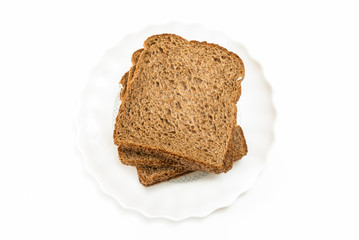 Whole grain sandwich bread slices on plate, on white background.