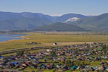 View on the village with many colorful houses on the shore of Lake Baikal in the mountains in the summer.