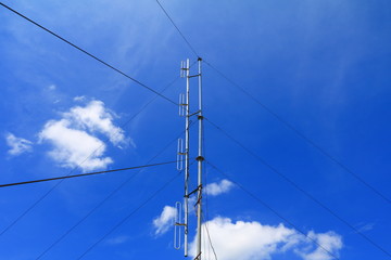 Fototapeta premium Telephone tower, telecommunication antenna radio on blue sky in background