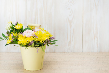 Composition of fresh flowers in a bucket on a wooden background. Copyspace
